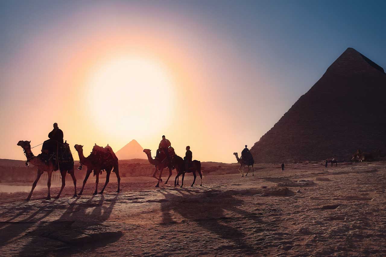 por do sol e camelos nas Piramides de Giza, no Cairo